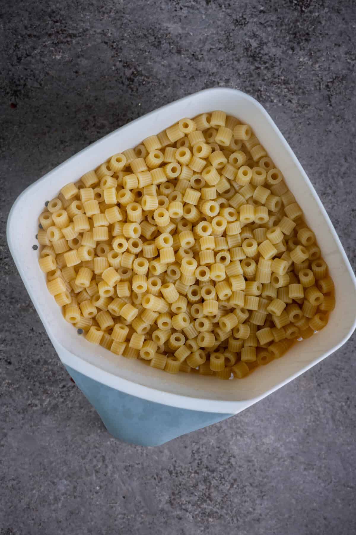 Drained cooked pasta resting in a colander.