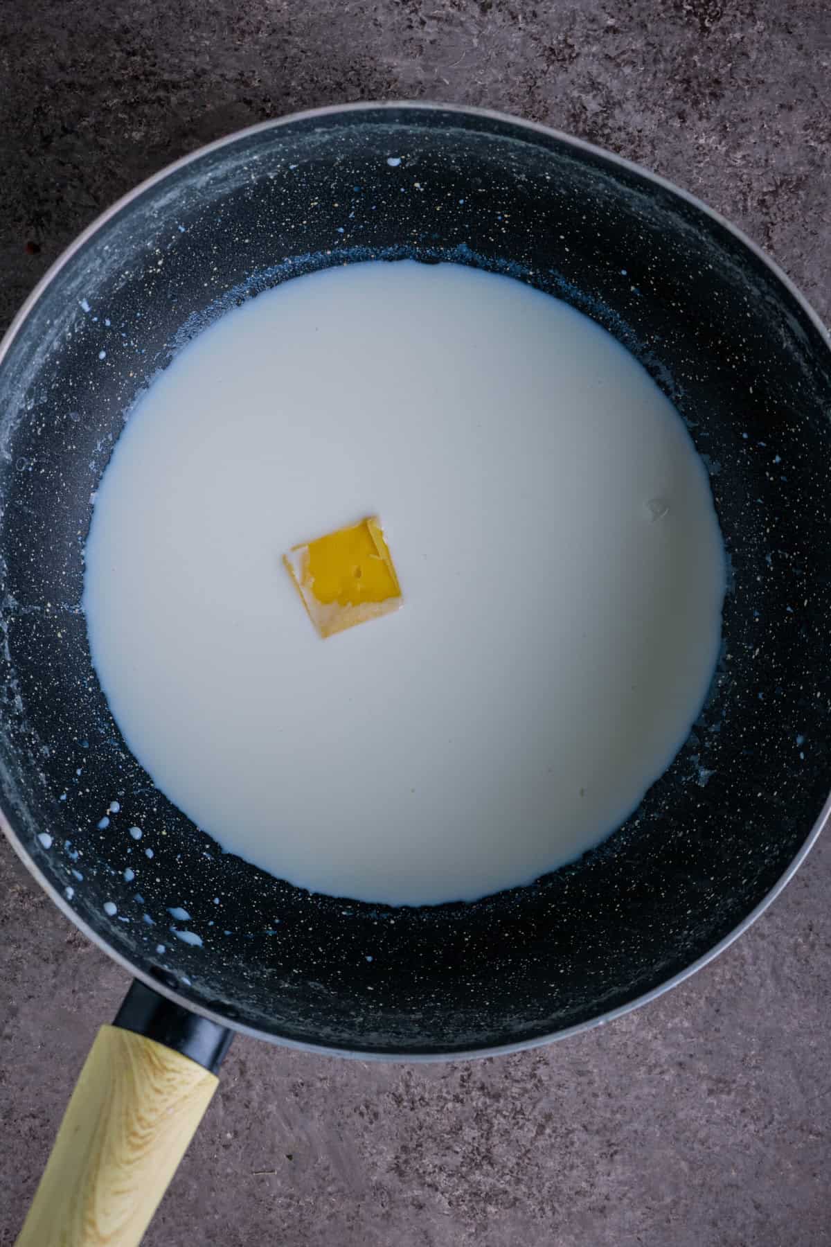 Milk and butter warming together in a saucepan on medium heat.
