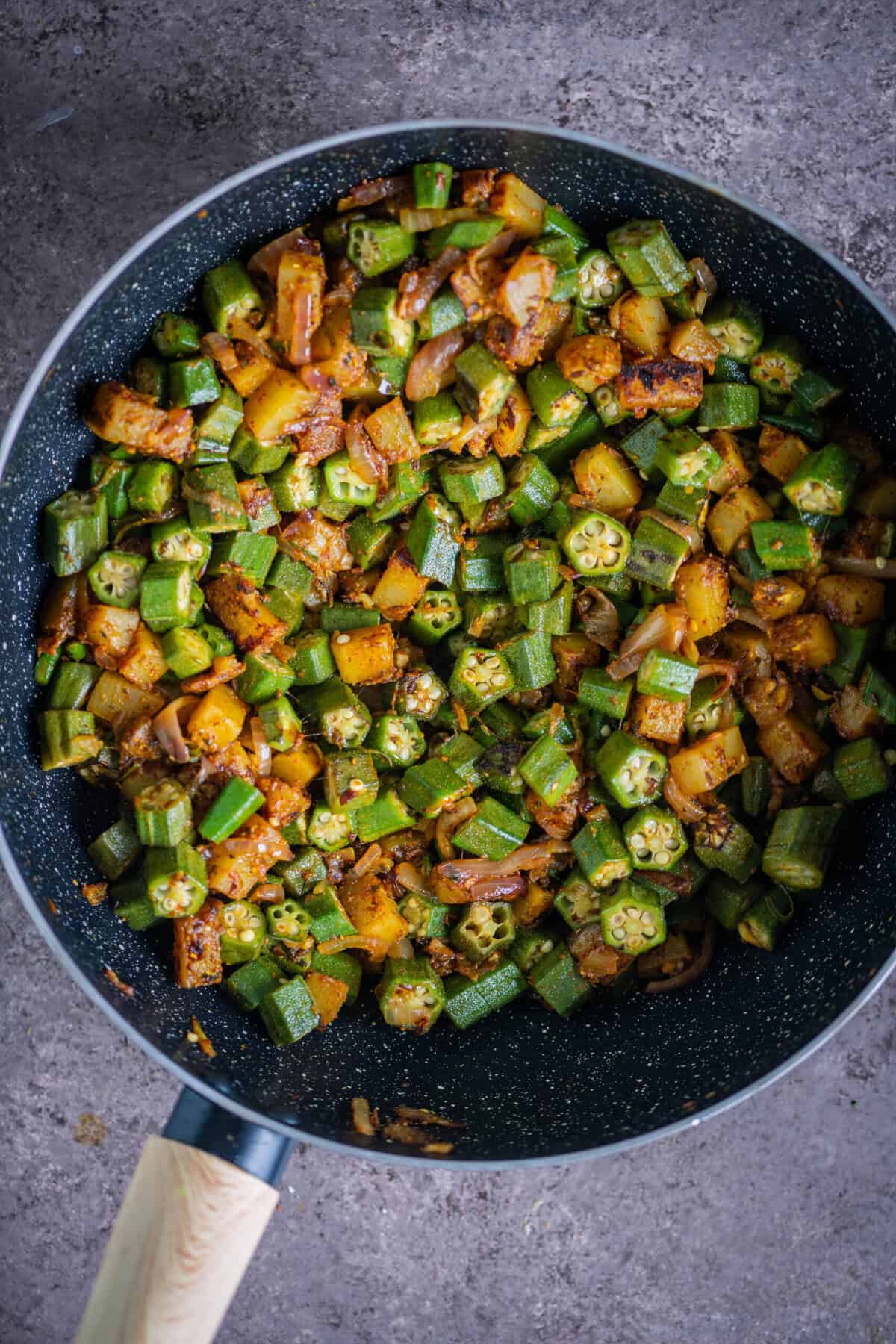 Sauteeing bhindi and potatoes on medium flame to achieve perfect non-slimy texture for Aloo Bhindi.