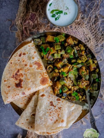 Indian Aloo Bhindi sabzi plated with roti, featuring a vibrant mix of sautéed okra and potatoes.