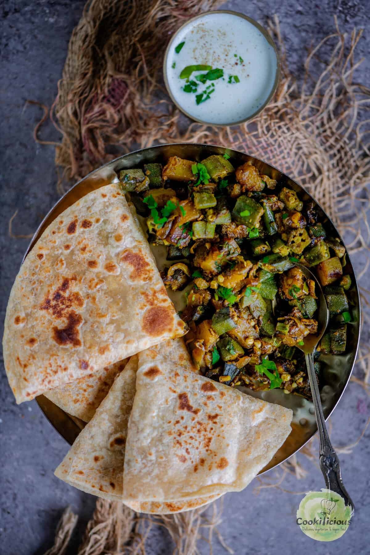 Indian Aloo Bhindi sabzi plated with roti, featuring a vibrant mix of sautéed okra and potatoes.