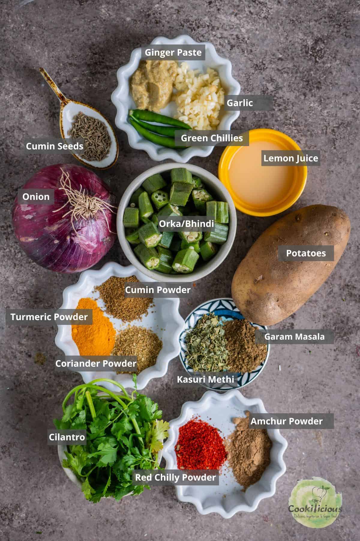 all the ingredients needed to make aloo bhindi placed on a table with labels on them.