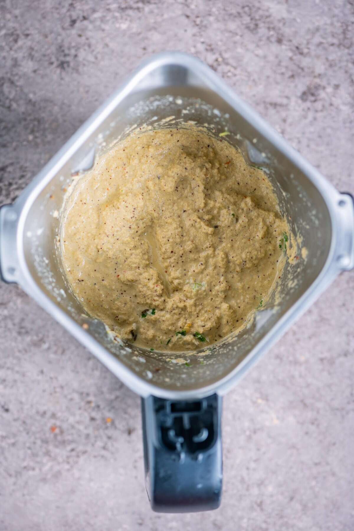 Smooth coconut spice paste in a blender, prepared for Poosanikai Poricha Kootu.