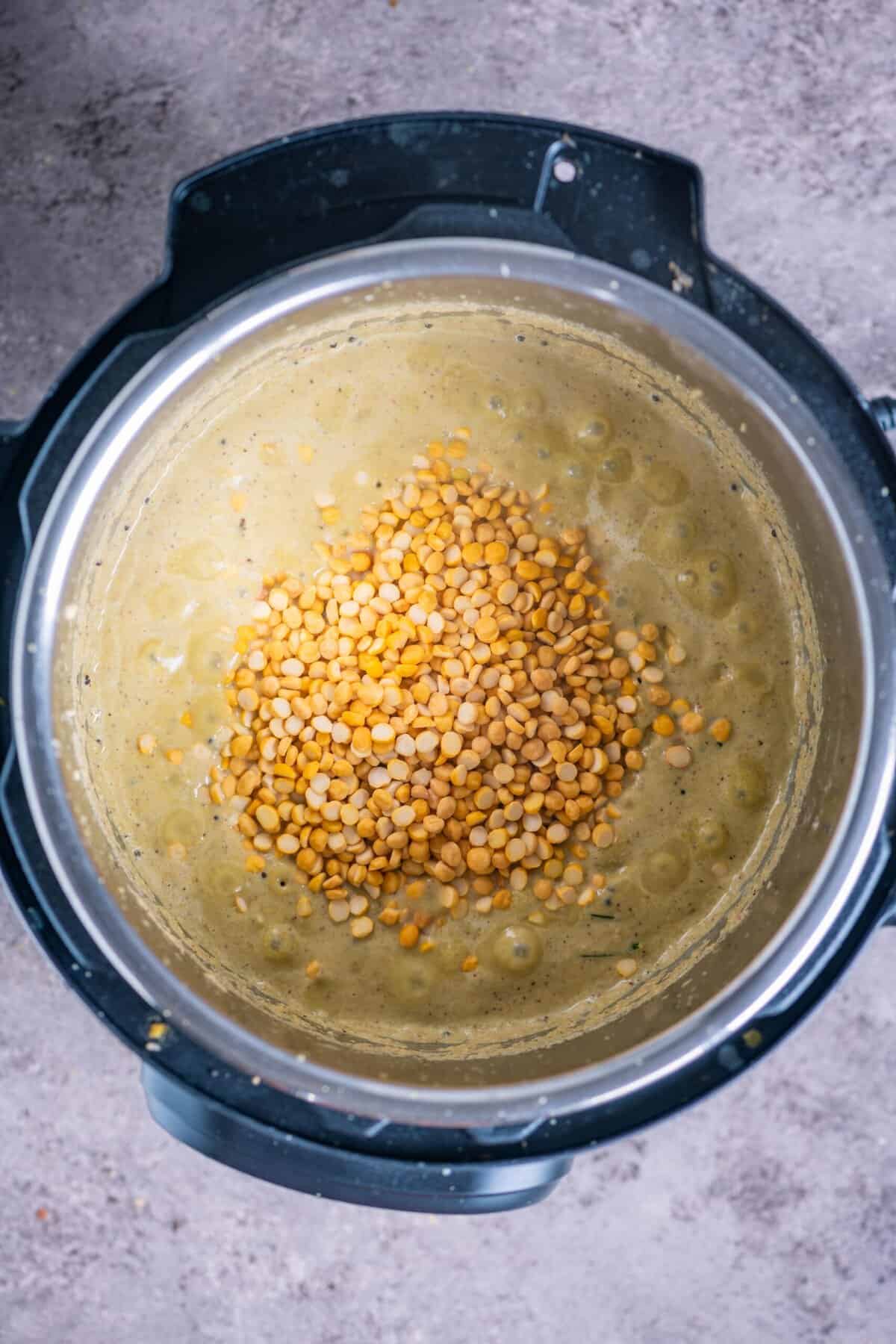 Rinsed chana dal being stirred into the white pumpkin curry mixture.