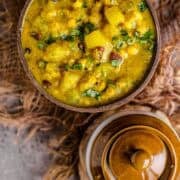 Bowl of creamy Poosanikai Kootu garnished with fresh cilantro, showing tender white pumpkin pieces.