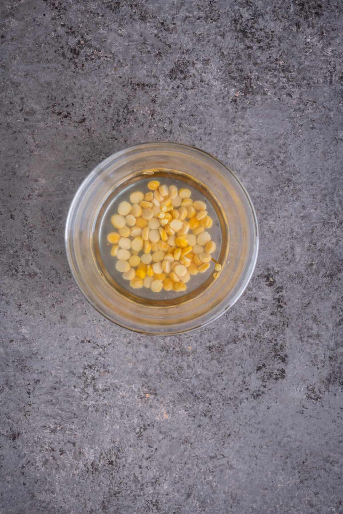 Chana dal soaking in water in a small bowl before making tomato rava upma.