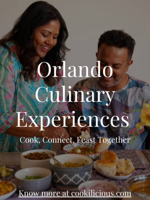 Man and woman smiling while cooking together and serving Indian food at an Orlando culinary experience by Cookilicious.