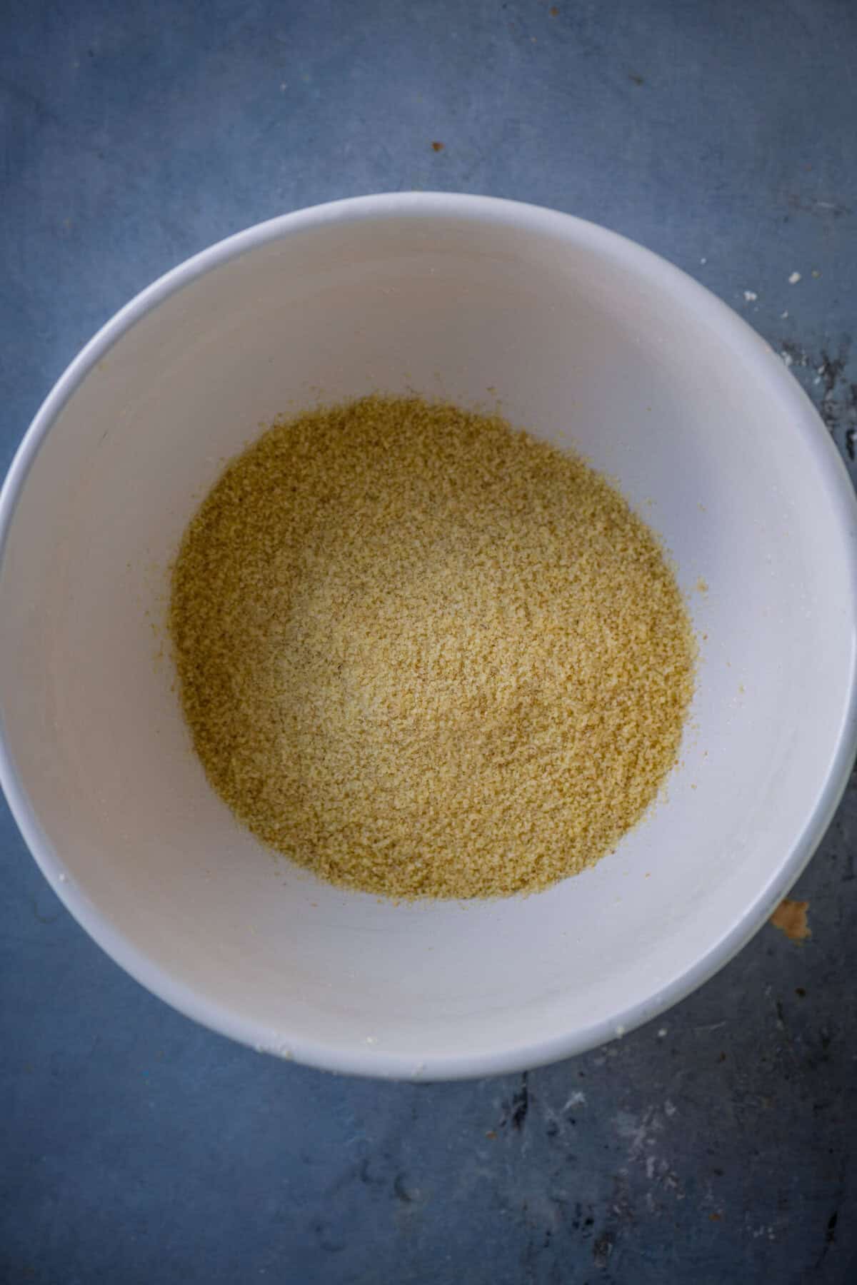 Fine rava (semolina) added to a mixing bowl for gulab jamun cupcake batter.