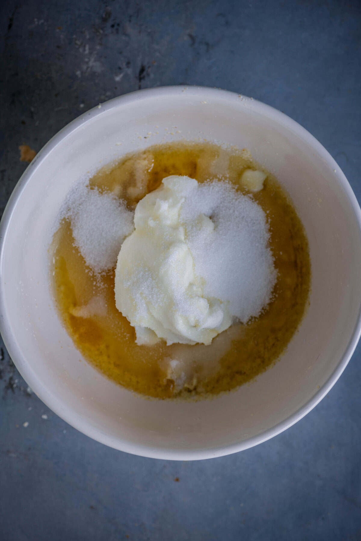 Adding sugar to rava cake batter.