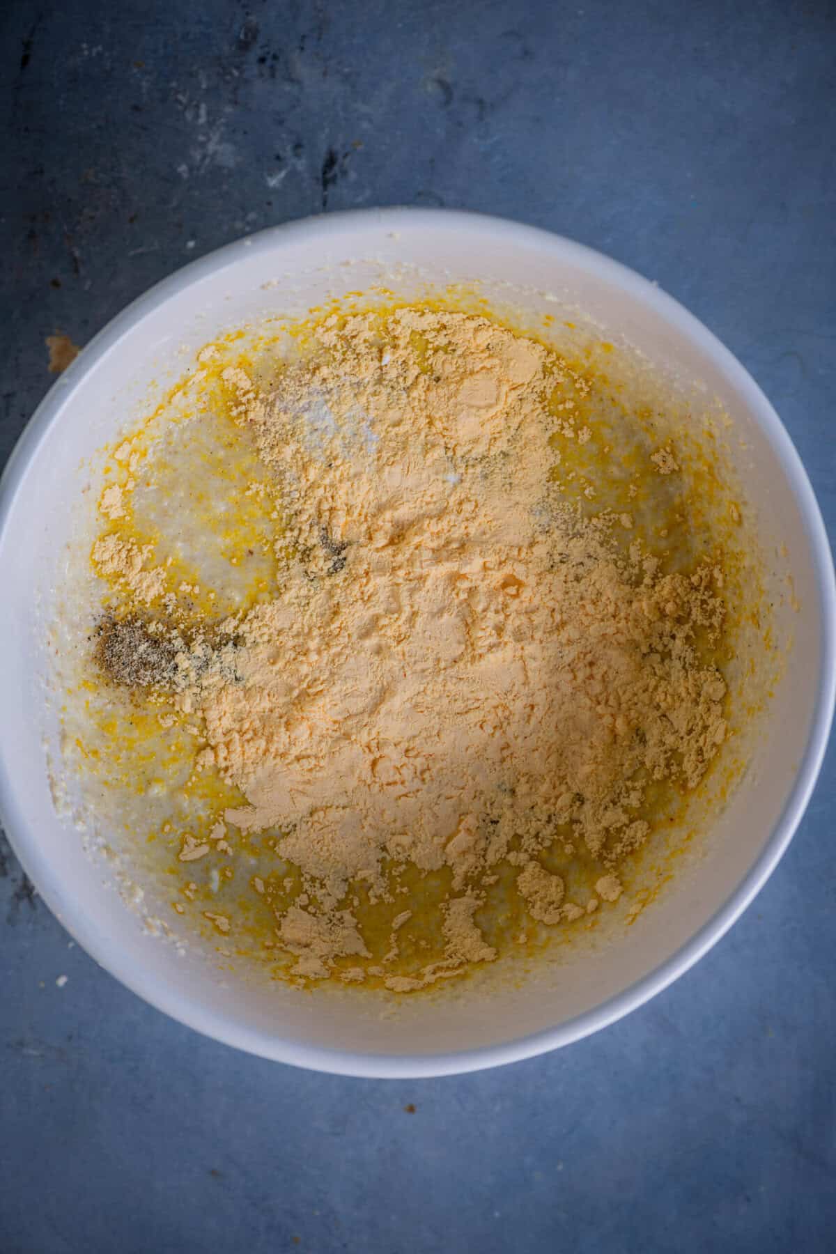 Adding custard powder to gulab jamun cupcake batter.