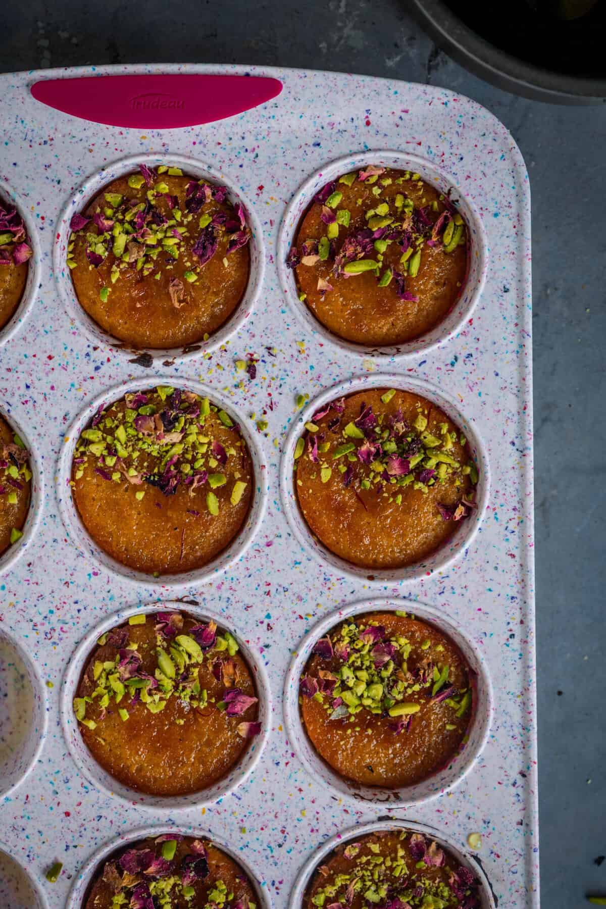 Gulab jamun cupcakes garnished with pistachios and edible rose petals, ready to serve.