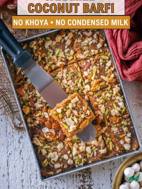 Pinterest pin for caramel coconut barfi with no khoya or condensed milk, showing sliced pieces topped with nuts in a metal tray.
