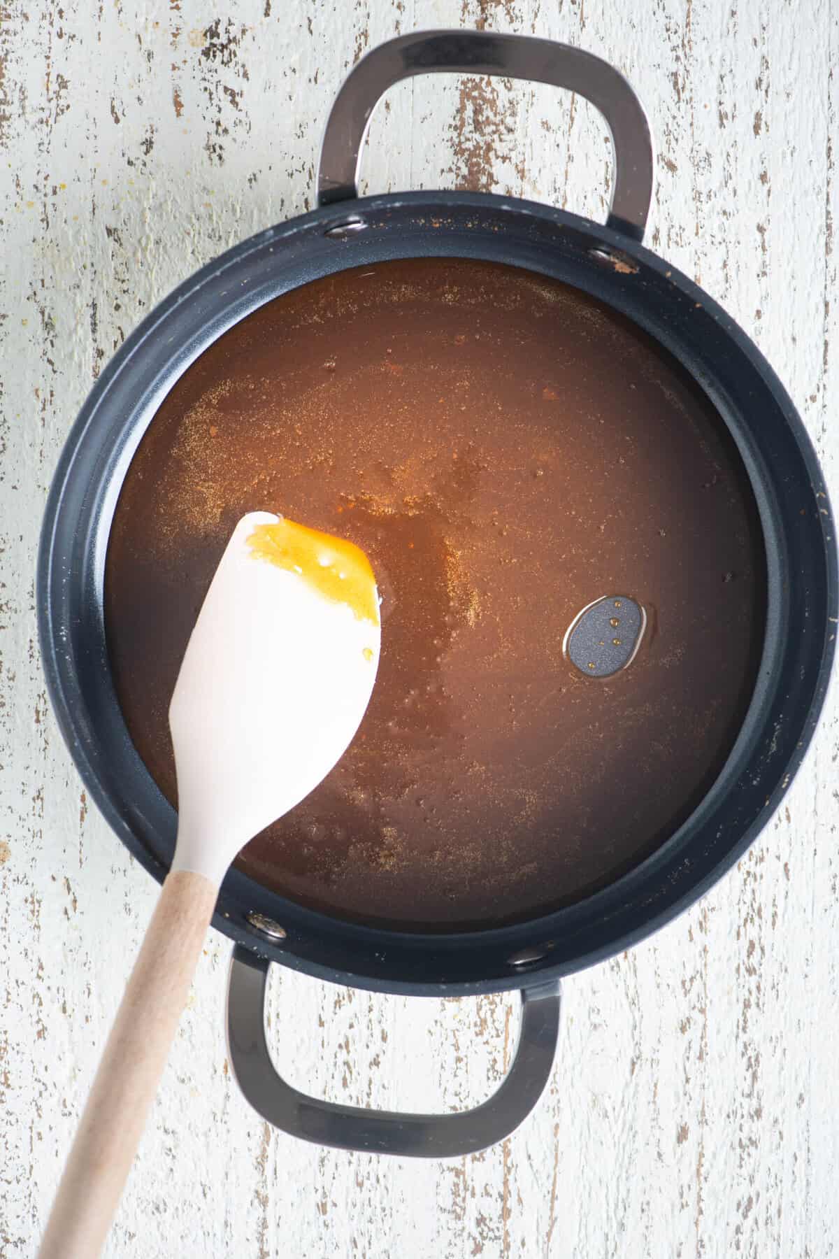 Dark caramelized sugar cooking in a pan.