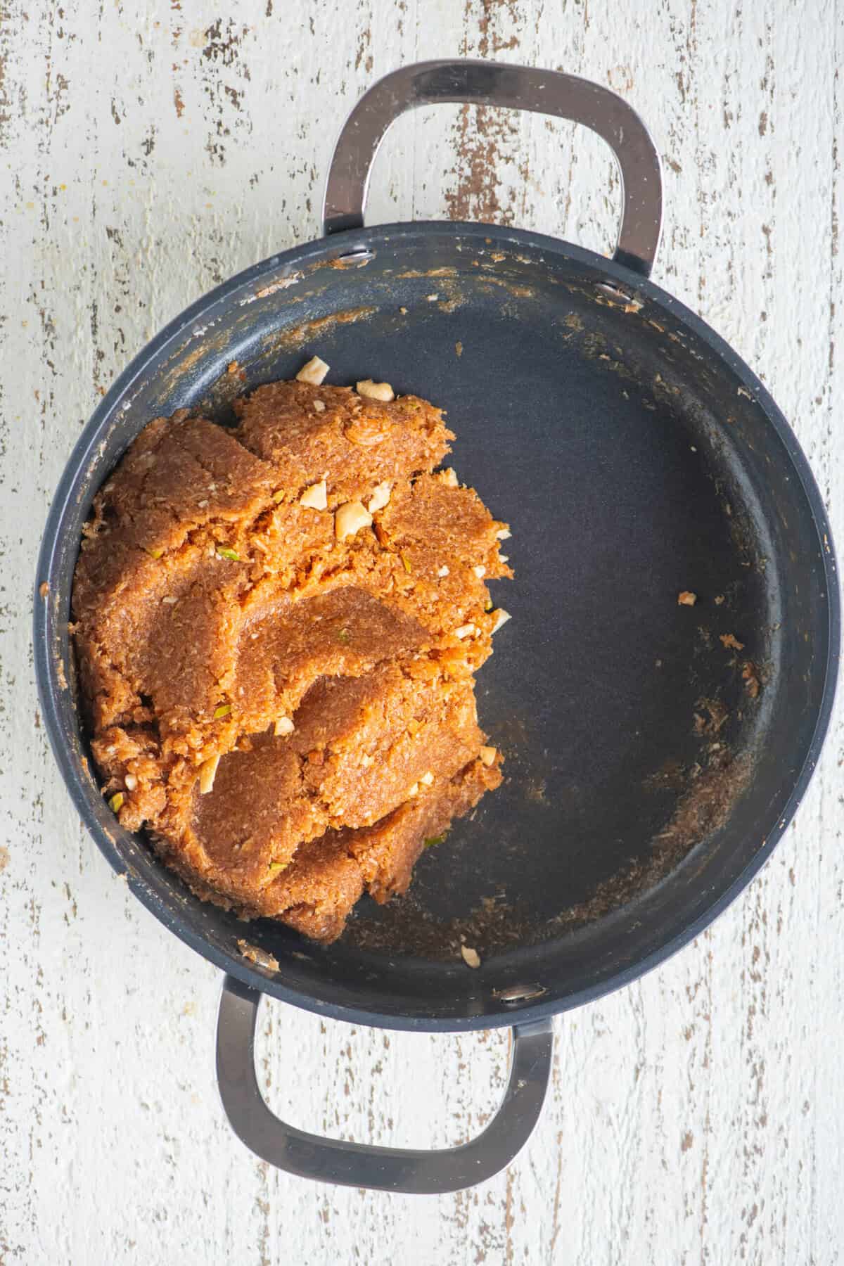 Caramel coconut barfi mixture coming together like a soft dough.